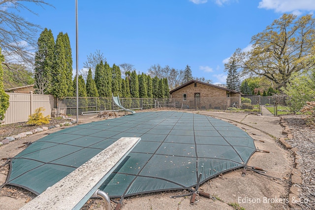 1657 W Kentview Dr NE, Grand Rapids, MI 49505 - view of swimming pool featuring a water slide, fence, and a diving board