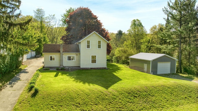 443 S Jackson St, Hanover, MI 49241 - back of property featuring a garage, an outdoor structure, and a lawn