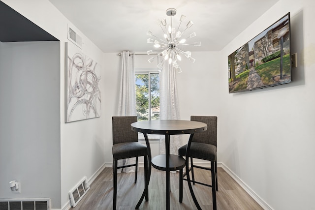 9601 Bayview Dr # 301, Ypsilanti, MI 48197 - dining space featuring a chandelier, wood finished floors, and baseboards