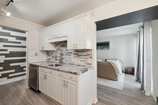 9601 Bayview Dr # 301, Ypsilanti, MI 48197 - kitchen featuring a sink, white cabinets, light wood finished floors, light stone countertops, and backsplash