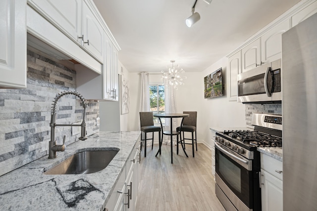 9601 Bayview Dr # 301, Ypsilanti, MI 48197 - kitchen with stainless steel appliances, a sink, tasteful backsplash, and white cabinetry