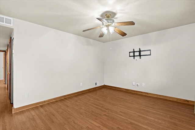 unfurnished room with wood finished floors, a ceiling fan, and baseboards
