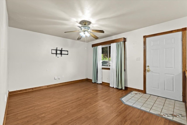 foyer entrance featuring light wood-type flooring, baseboards, and ceiling fan
