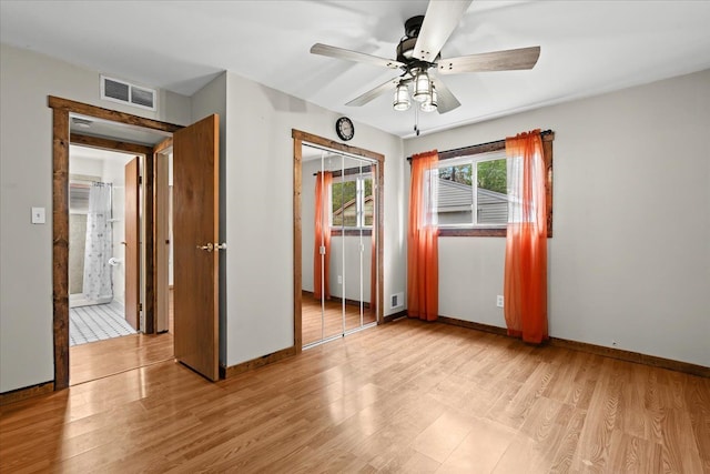 spare room with ceiling fan, light wood-type flooring, and baseboards