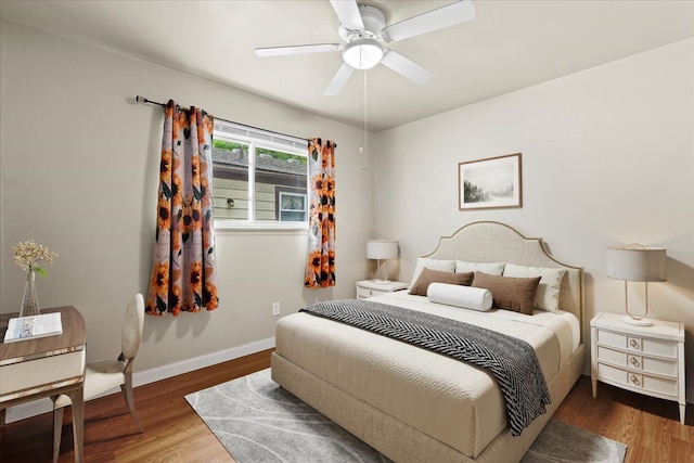 bedroom featuring wood finished floors, baseboards, and ceiling fan