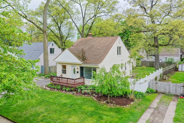 view of front of home featuring a wooden deck, a shingled roof, a chimney, and asphalt driveway