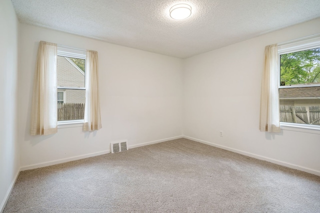 unfurnished room featuring carpet floors, a textured ceiling, and baseboards