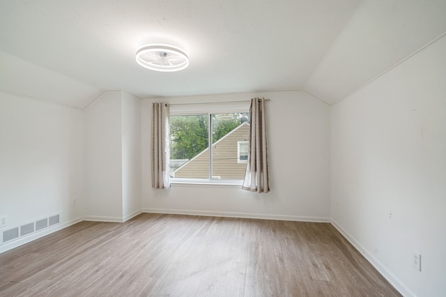 additional living space featuring lofted ceiling, wood finished floors, and baseboards