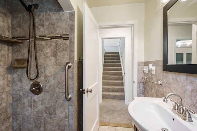 full bath with a tile shower and a sink