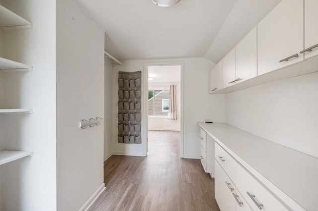 spacious closet featuring light wood-type flooring and lofted ceiling