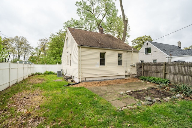 back of house featuring a chimney, cooling unit, and a patio