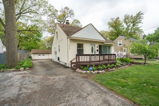 view of front facade with a chimney, a wooden deck, a detached garage, an outdoor structure, and a shingled roof