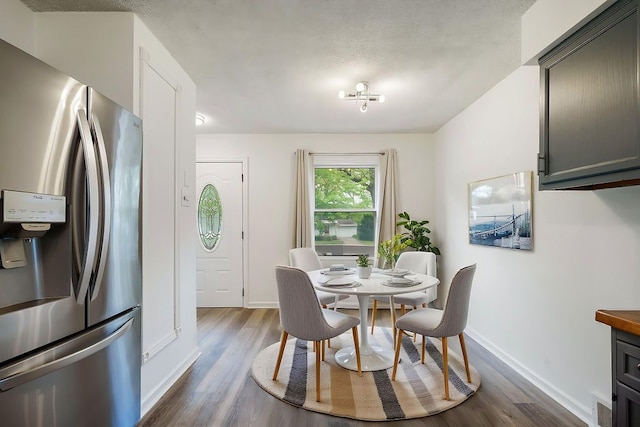 dining space with dark wood-type flooring and baseboards