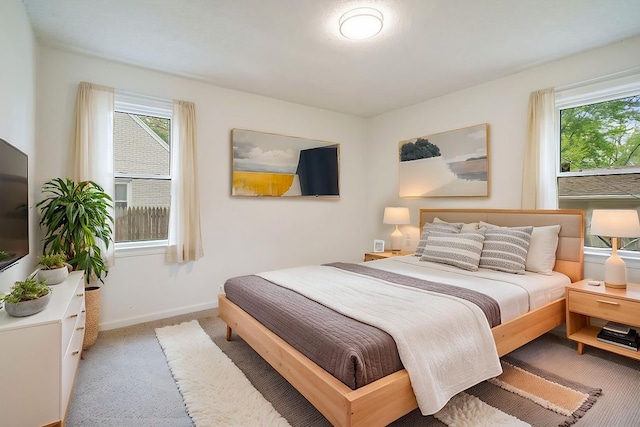 bedroom featuring light colored carpet and baseboards