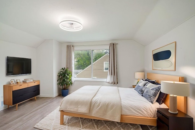 bedroom featuring vaulted ceiling, wood finished floors, and baseboards