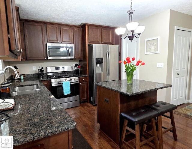 465 Edgewood Pass, Fenton, MI 48430 - kitchen with appliances with stainless steel finishes, a sink, dark wood finished floors, a kitchen bar, and a textured ceiling