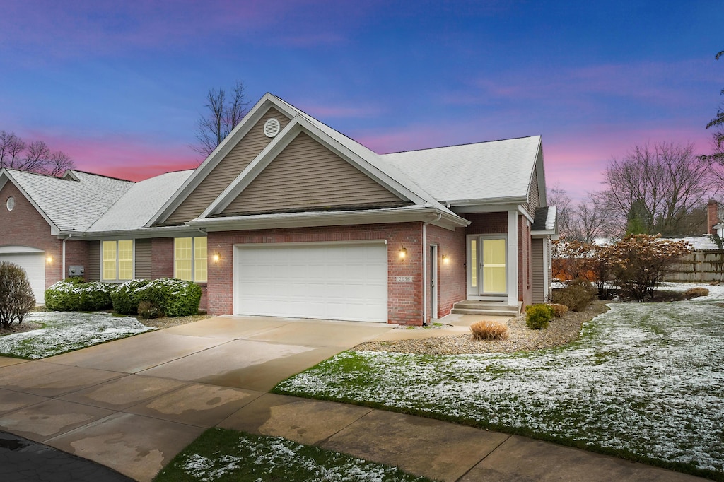 view of front of property featuring driveway, a garage, and brick siding