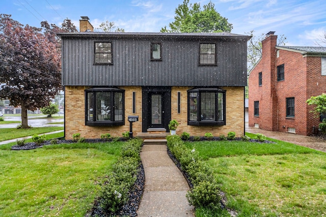 21984 Wildwood St, Dearborn, MI 48128 - view of front facade with a front yard, brick siding, and a chimney