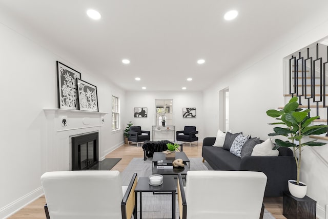 21984 Wildwood St, Dearborn, MI 48128 - living area featuring a glass covered fireplace, recessed lighting, light wood-style floors, and baseboards