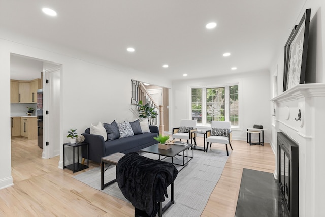21984 Wildwood St, Dearborn, MI 48128 - living area with stairway, recessed lighting, light wood-style flooring, baseboards, and a fireplace with flush hearth