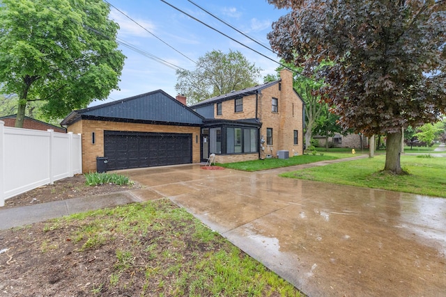 21984 Wildwood St, Dearborn, MI 48128 - view of front of property with driveway, central AC, a garage, and brick siding