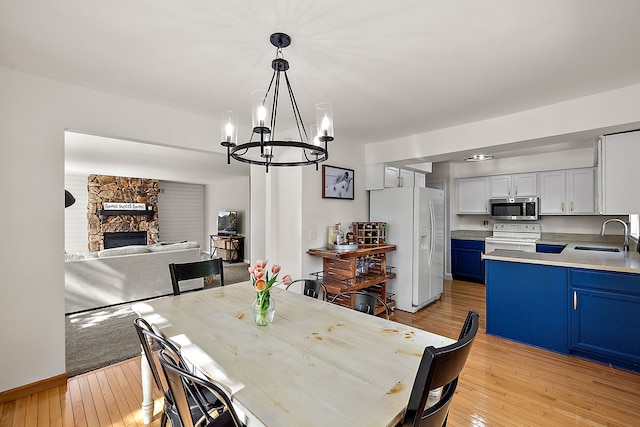 2015 Hazel Ave, Wixom, MI 48393 - dining space with light wood finished floors, a chandelier, and a fireplace