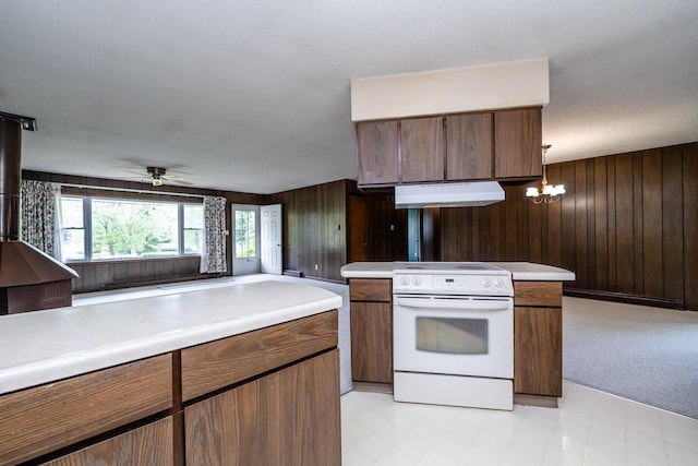 5575 Meadowbrook Rd, Eau Claire, MI 49111 - kitchen with white electric range, under cabinet range hood, wooden walls, light countertops, and a ceiling fan
