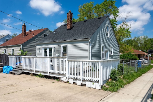 26613 W Hills Dr, Inkster, MI 48141 - view of side of property featuring a deck, a shingled roof, a chimney, and a patio