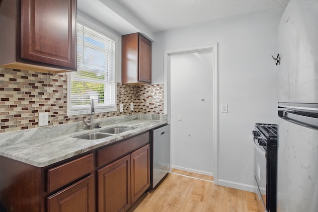 26613 W Hills Dr, Inkster, MI 48141 - kitchen featuring a sink, dishwasher, range with gas stovetop, freestanding refrigerator, and light wood-style flooring