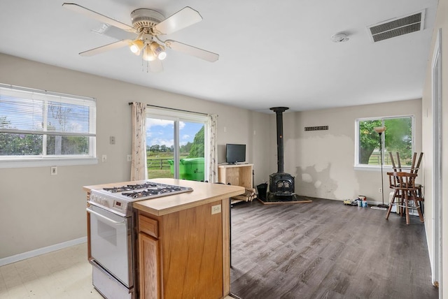 kitchen with white gas stove, plenty of natural light, a wood stove, and open floor plan