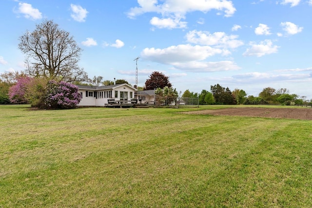 view of grassy yard with a deck