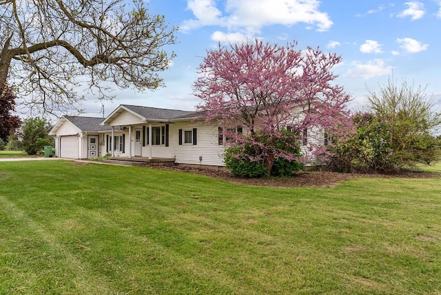 ranch-style house featuring covered porch, an attached garage, and a front yard