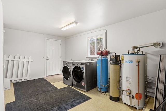 clothes washing area with gas water heater and washing machine and dryer
