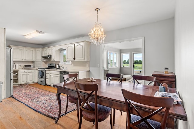dining space featuring a chandelier and light wood-type flooring