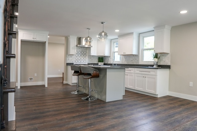 278 W Saint Clair St, Romeo, MI 48065 - kitchen with wall chimney exhaust hood, baseboards, a center island, dark wood finished floors, and white cabinets