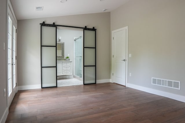 278 W Saint Clair St, Romeo, MI 48065 - unfurnished room with a barn door, wood finished floors, baseboards, and lofted ceiling