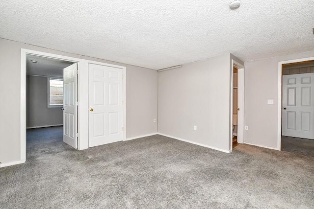 unfurnished bedroom with carpet floors, baseboards, and a textured ceiling