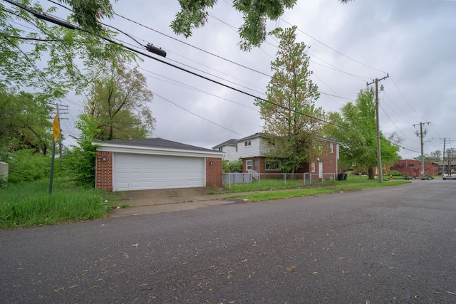 view of front of property featuring brick siding, an outbuilding, and a detached garage