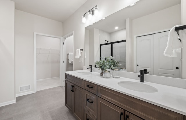 55697 Oak Pointe Dr, Utica, MI 48315 - bathroom featuring a shower stall, double vanity, a walk in closet, and baseboards
