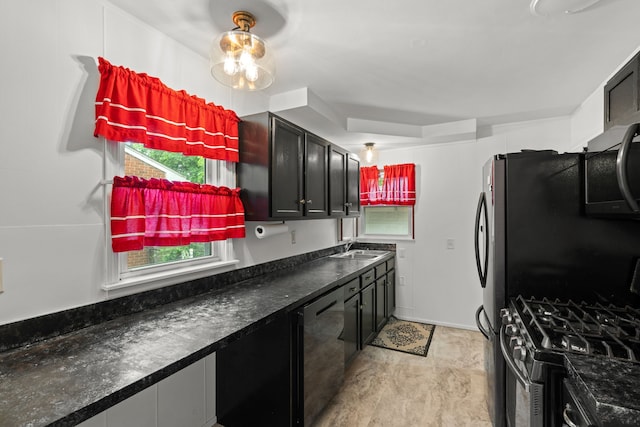 kitchen featuring dishwasher, a sink, stainless steel gas range oven, and dark countertops