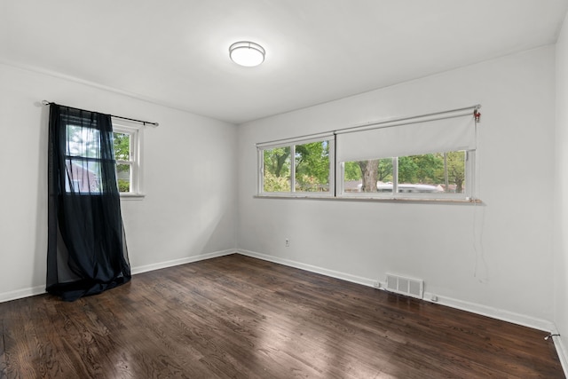 empty room featuring dark wood-style floors and baseboards