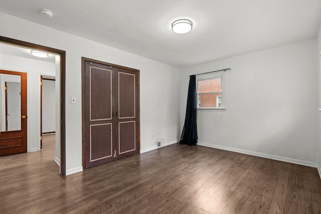 unfurnished bedroom featuring dark wood-style floors and baseboards