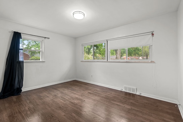 empty room with dark wood finished floors and baseboards