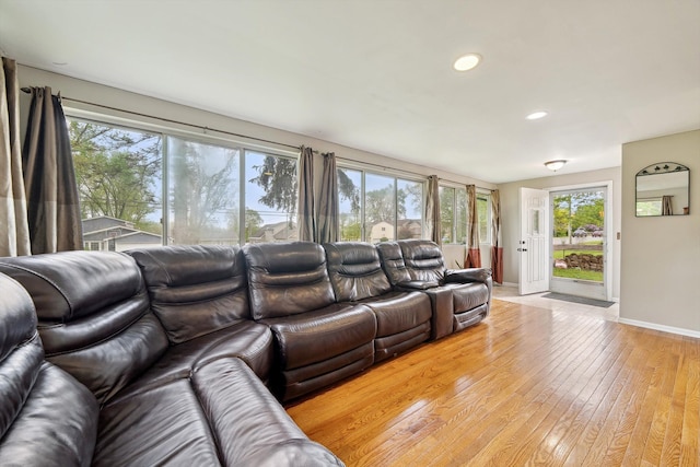 living area featuring baseboards, light wood-style floors, and recessed lighting