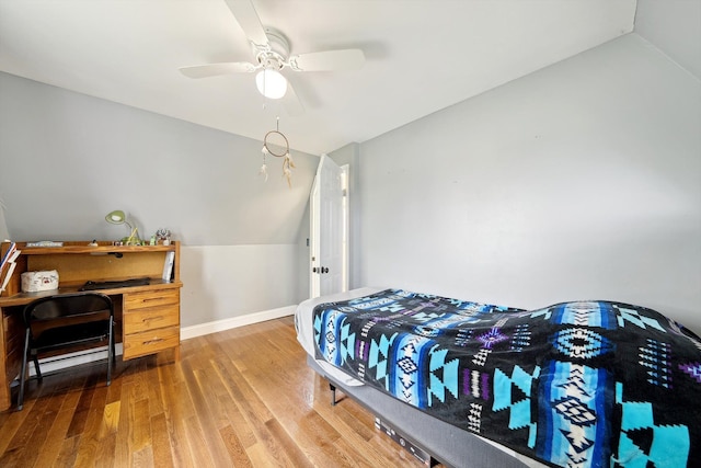 bedroom featuring vaulted ceiling, wood finished floors, baseboards, and ceiling fan