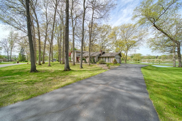 216 Wickenham Dr, Spring Arbor, MI 49283 - view of front of property with a water view, a front lawn, and asphalt driveway