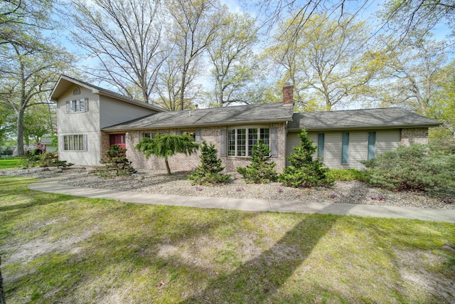 216 Wickenham Dr, Spring Arbor, MI 49283 - view of front of house with a front lawn, a chimney, and brick siding