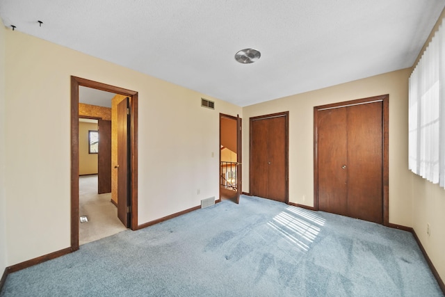 216 Wickenham Dr, Spring Arbor, MI 49283 - unfurnished bedroom with light carpet, two closets, and baseboards