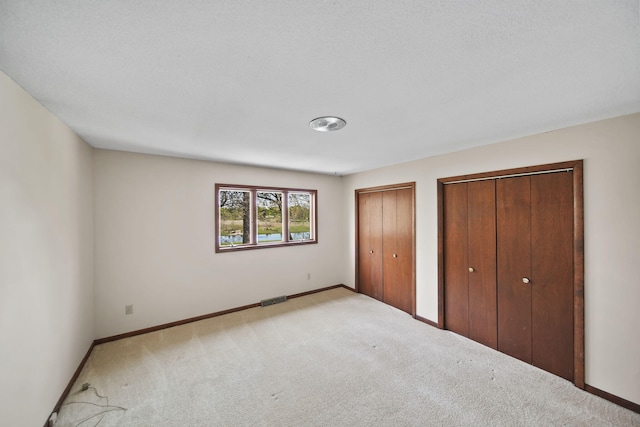 216 Wickenham Dr, Spring Arbor, MI 49283 - unfurnished bedroom featuring multiple closets, carpet floors, and baseboards