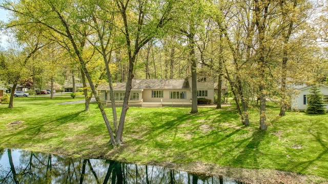 216 Wickenham Dr, Spring Arbor, MI 49283 - rear view of house featuring a lawn and a water view